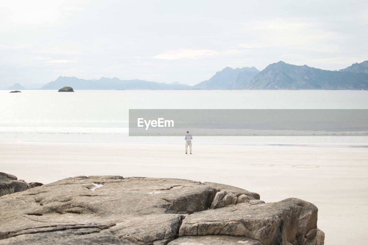 Rear view of man standing at beach