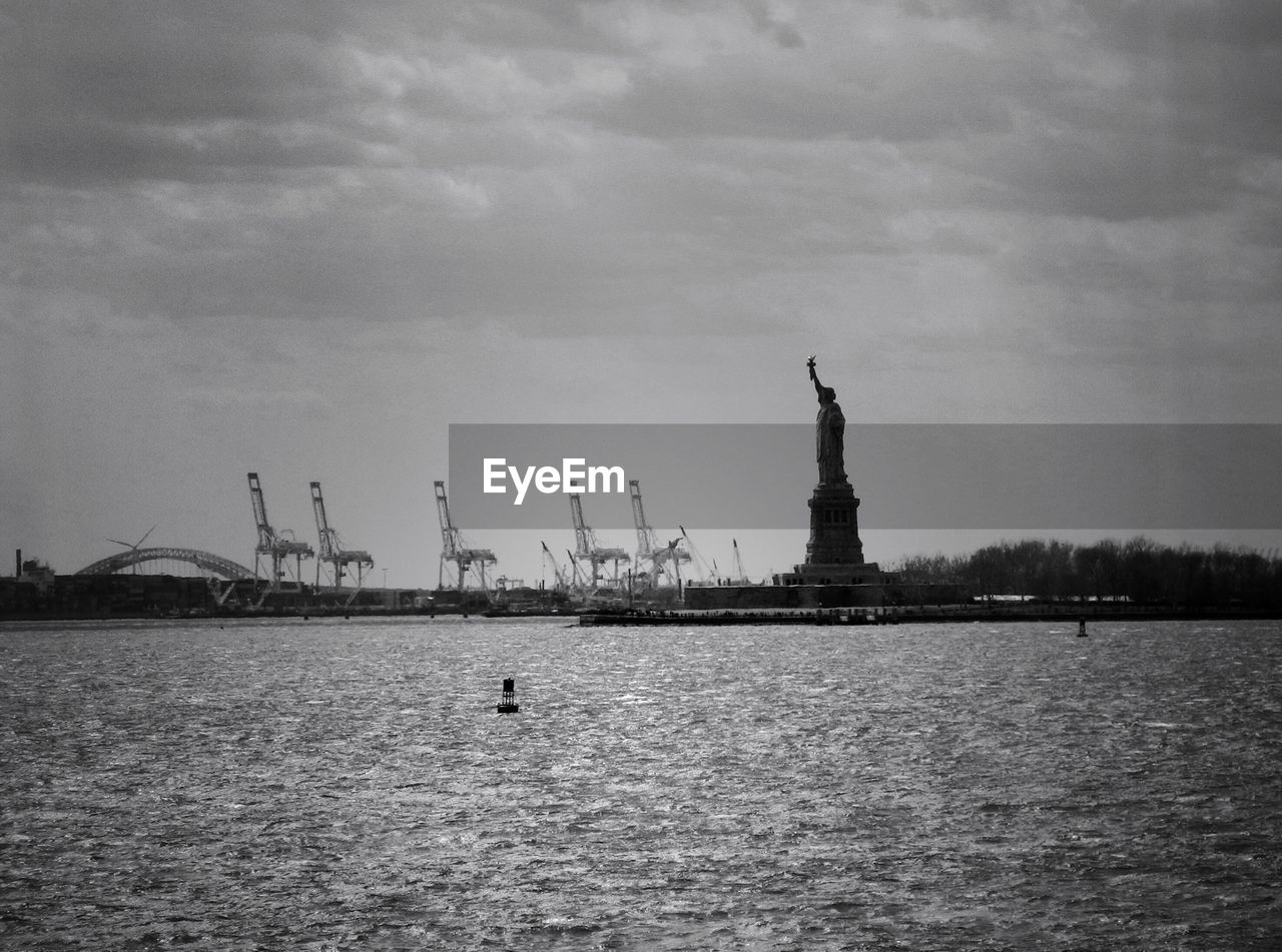 Statue of liberty by hudson river against sky