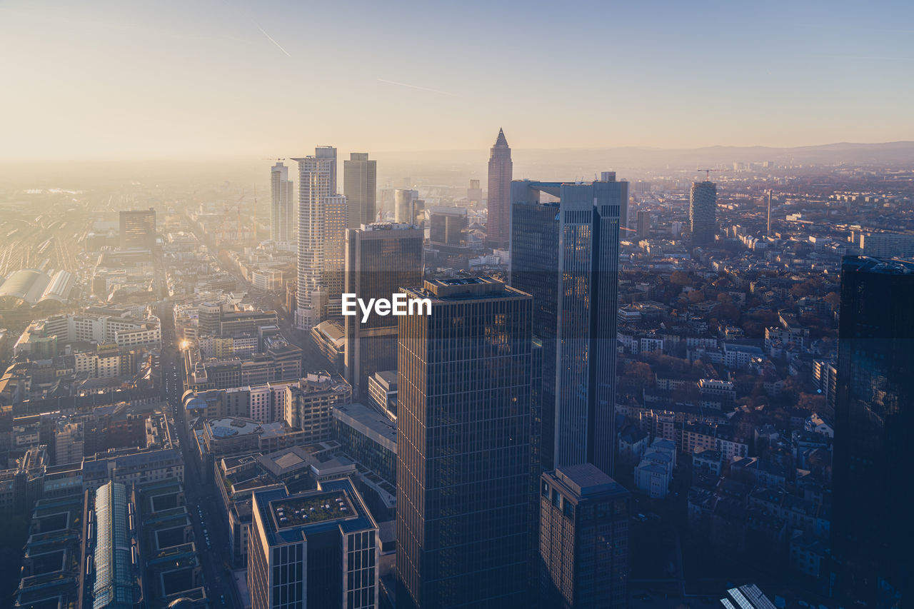 Aerial view of illuminated buildings in city during sunset