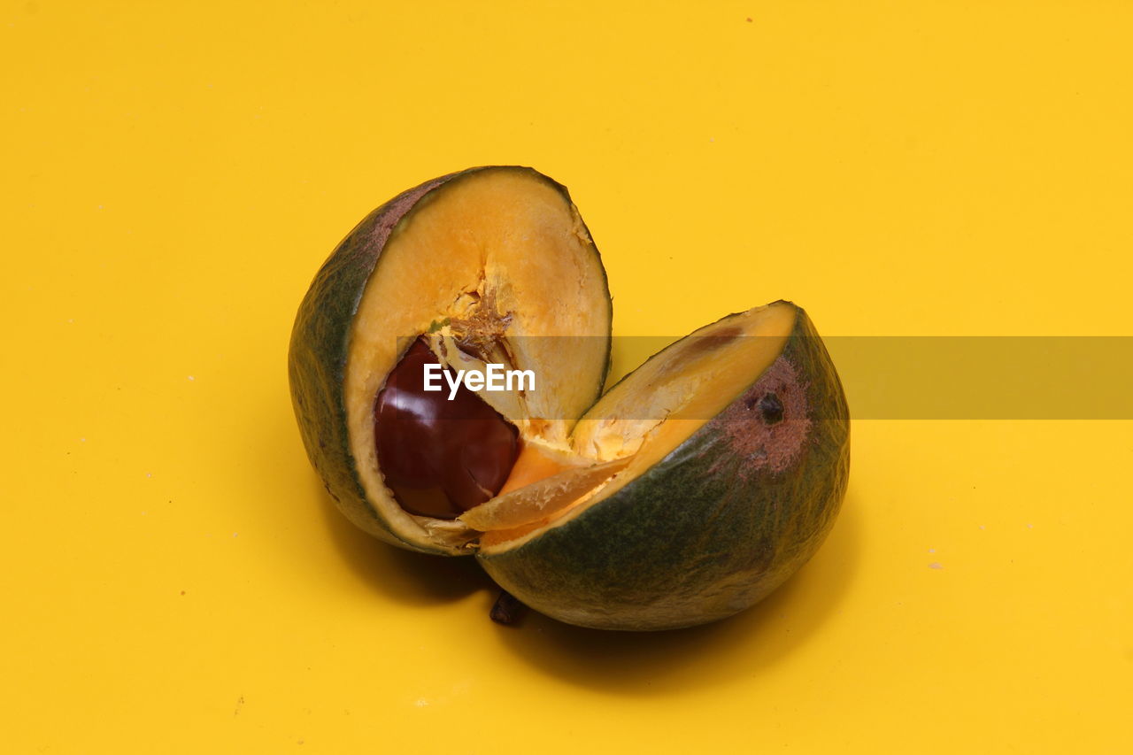 Close-up of avocado over yellow background