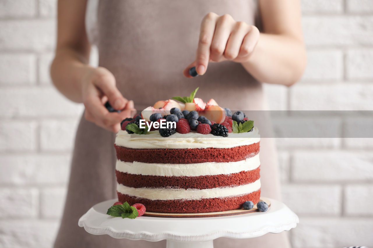 Midsection of woman holding cake