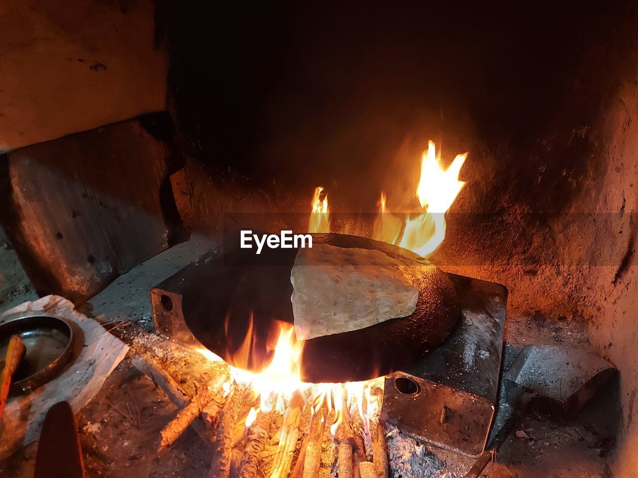 CLOSE-UP OF BURNING CANDLES IN METAL CONTAINER