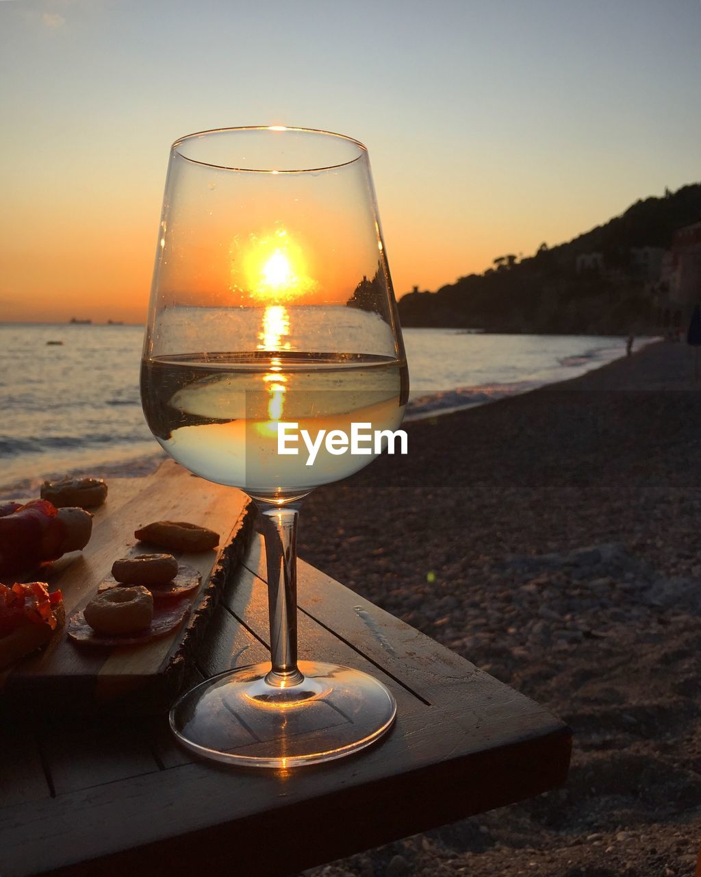 Close-up of wine glass on beach