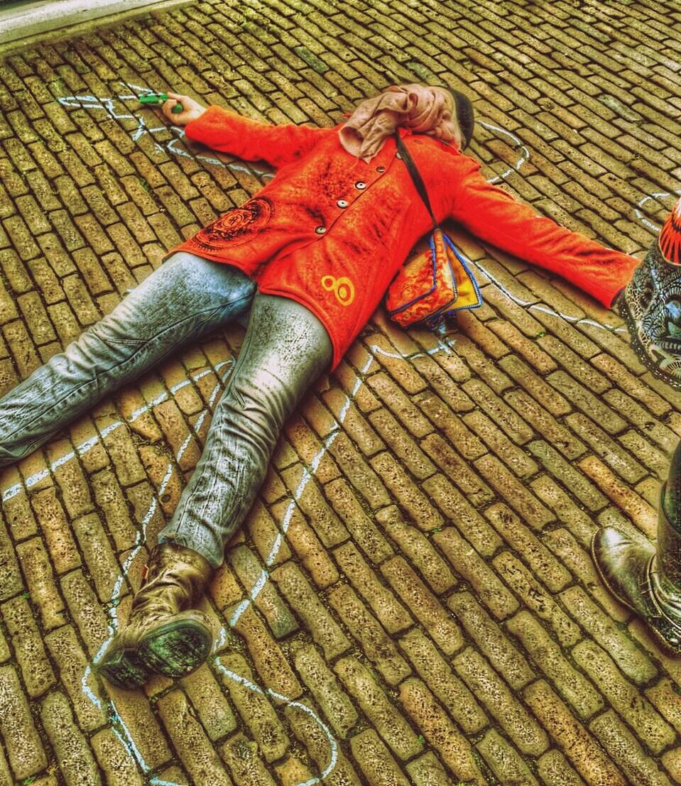 High angle view of woman lying down on street