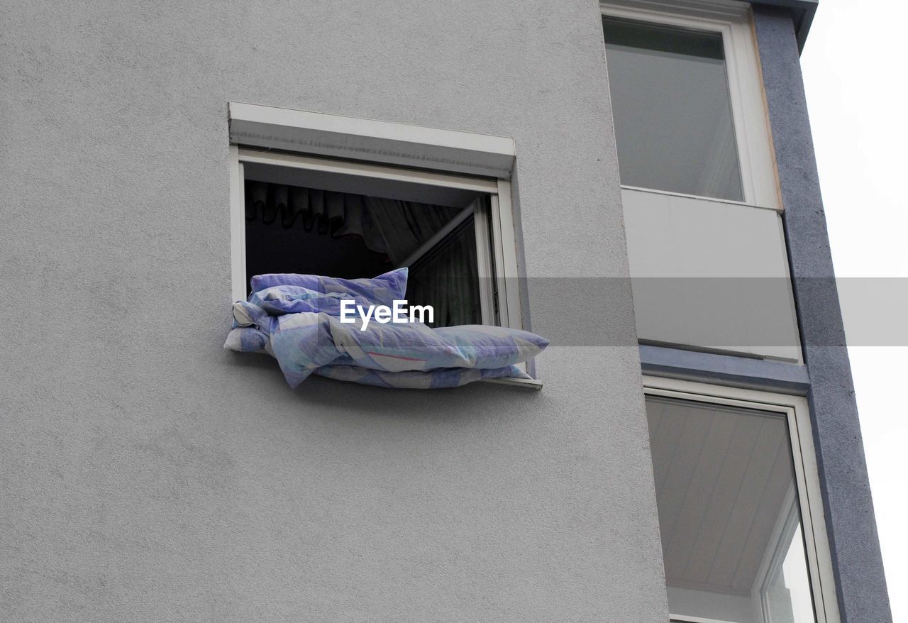 LOW ANGLE VIEW OF WINDOW HANGING ON HOUSE WALL