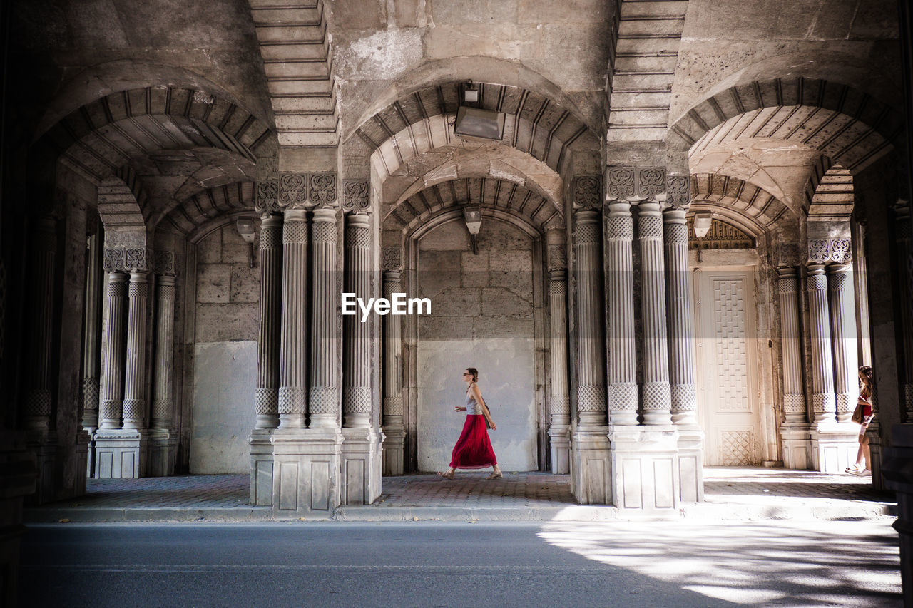 Side view of woman standing in historic building