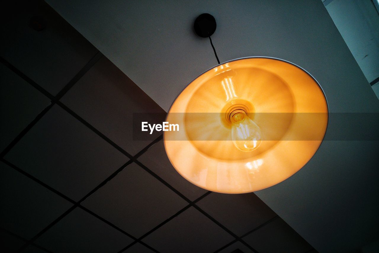 Low angle view of pendant light on ceiling in darkroom