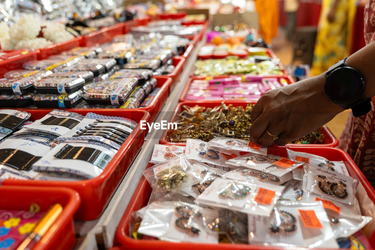 market, retail, city, public space, hand, food, one person, variation, food and drink, market stall, adult, abundance, business finance and industry, business, supermarket, marketplace, shopping, store, choosing, large group of objects, selective focus, freshness, bazaar, indoors, for sale