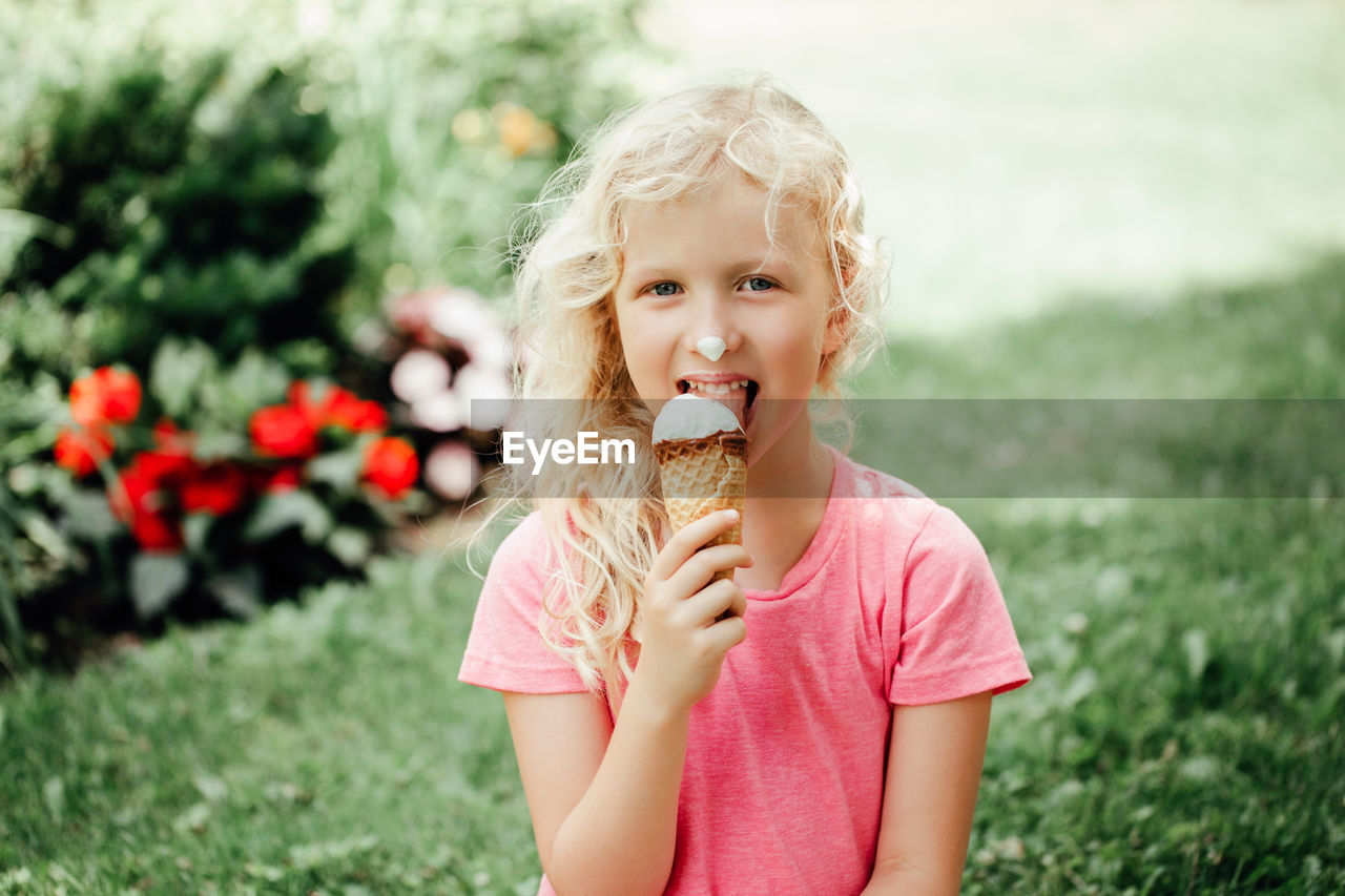 Portrait of cute girl eating ice cream outdoors