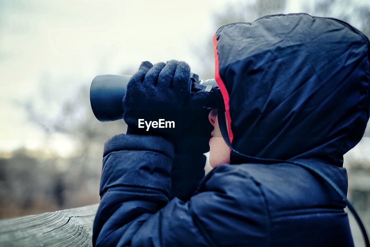 Young woman looking through binoculars