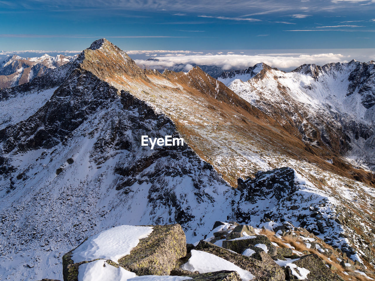 Scenic fall view of snowcapped mountains against sky.