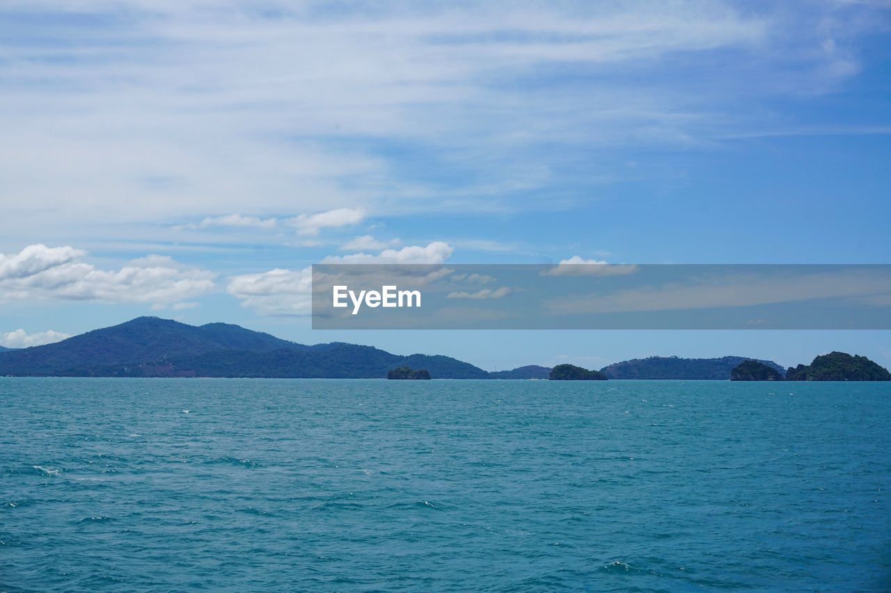 SCENIC VIEW OF SEA BY MOUNTAINS AGAINST SKY