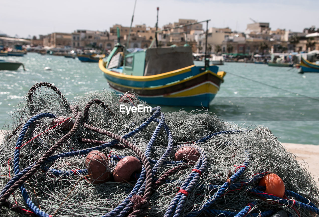 Close-up of fishing net at harbor in city