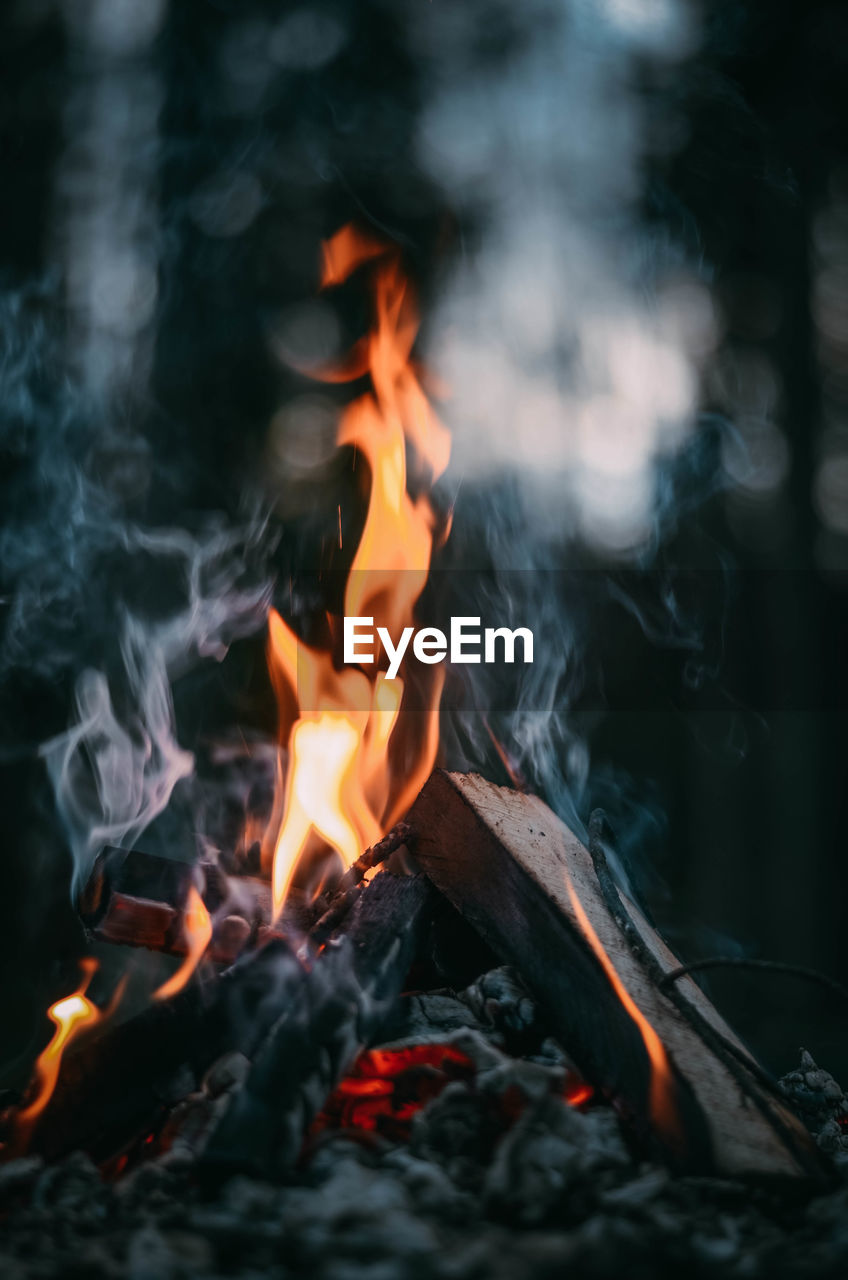 CLOSE-UP OF BONFIRE WITH FIRE IN BACKGROUND