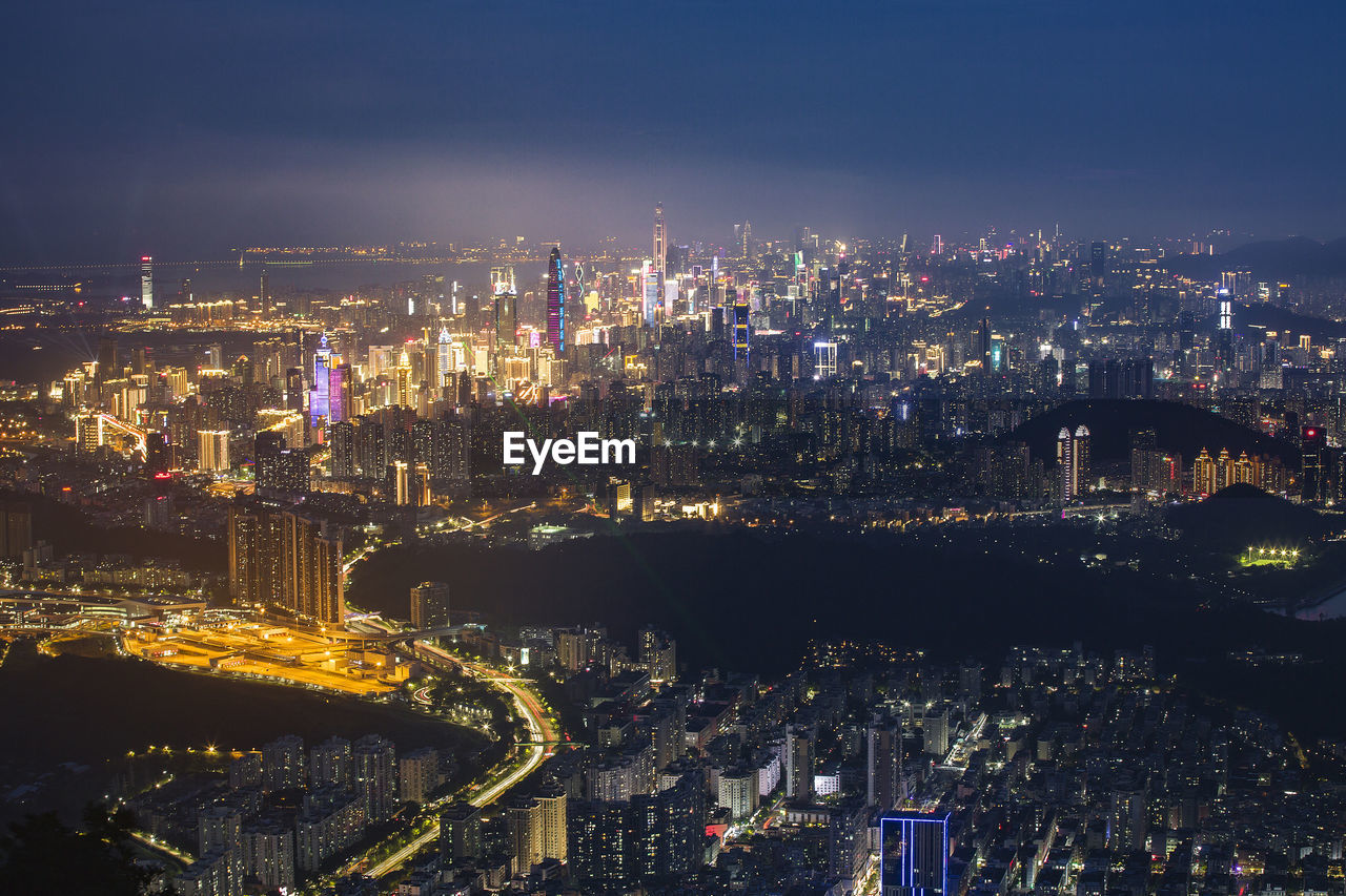 HIGH ANGLE VIEW OF ILLUMINATED BUILDINGS IN CITY AT NIGHT