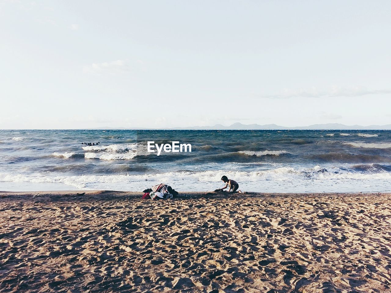 Girl playing at beach against sky