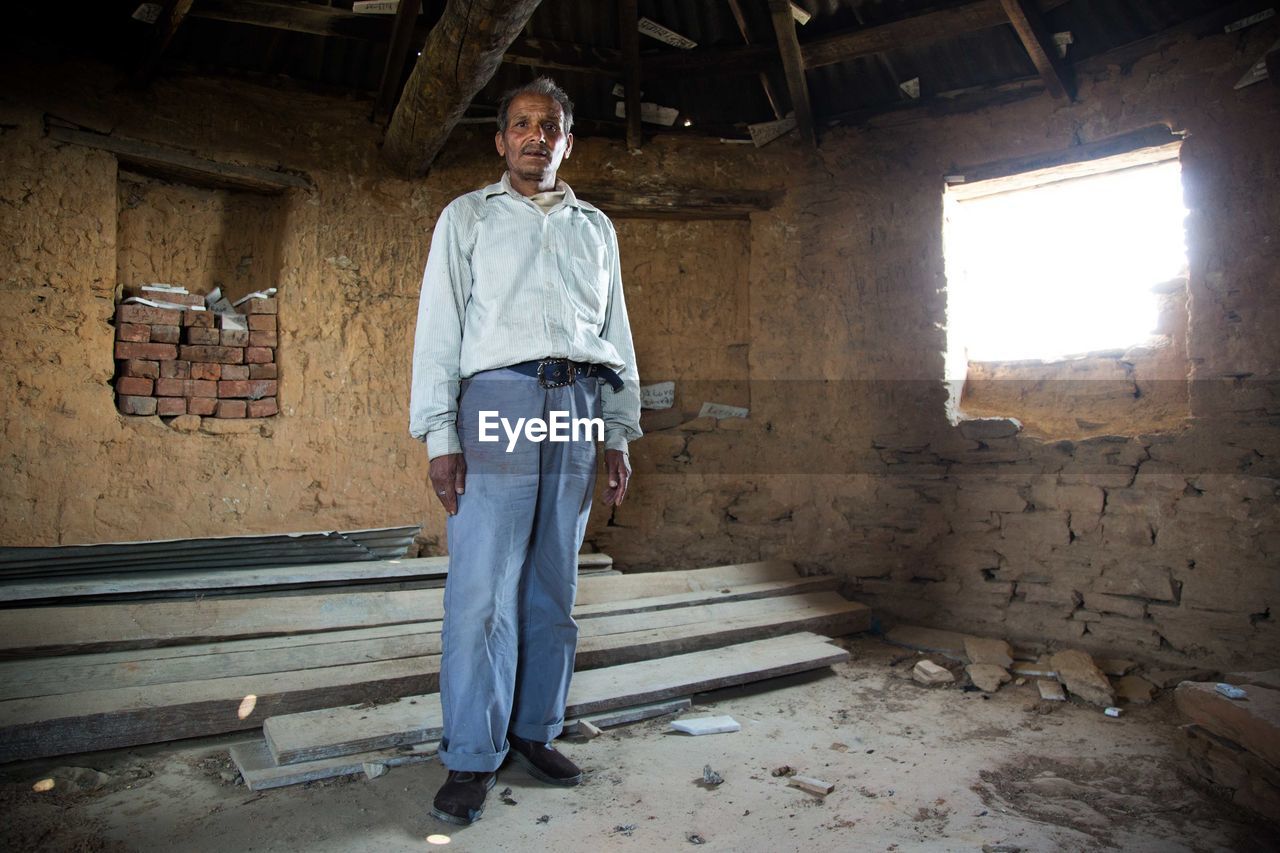 Portrait of mature man standing in abandoned house