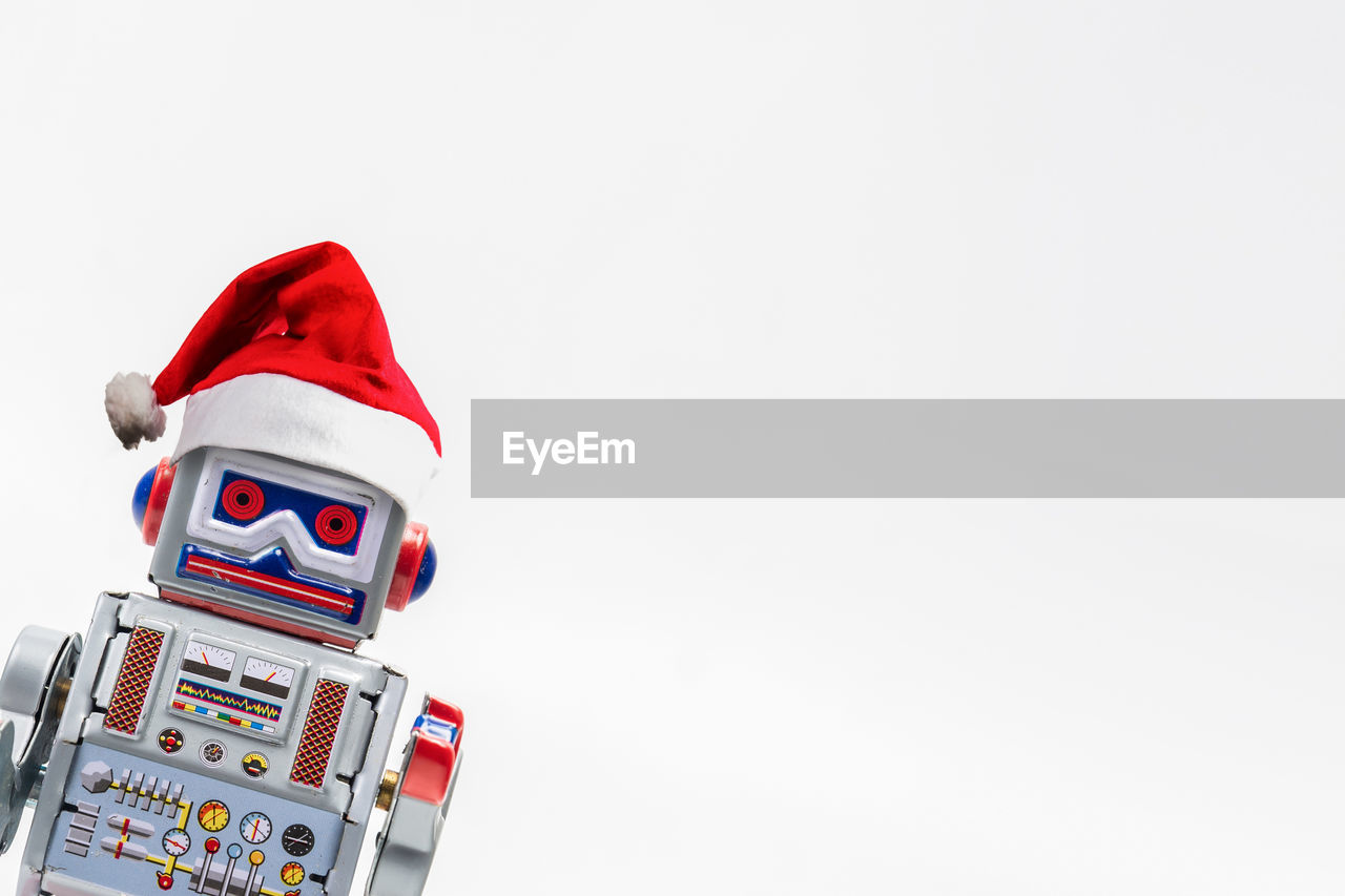 Robot in santa hat over white background