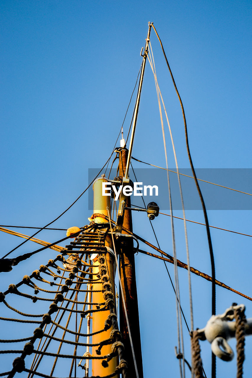 LOW ANGLE VIEW OF CRANE AT CONSTRUCTION SITE AGAINST CLEAR BLUE SKY