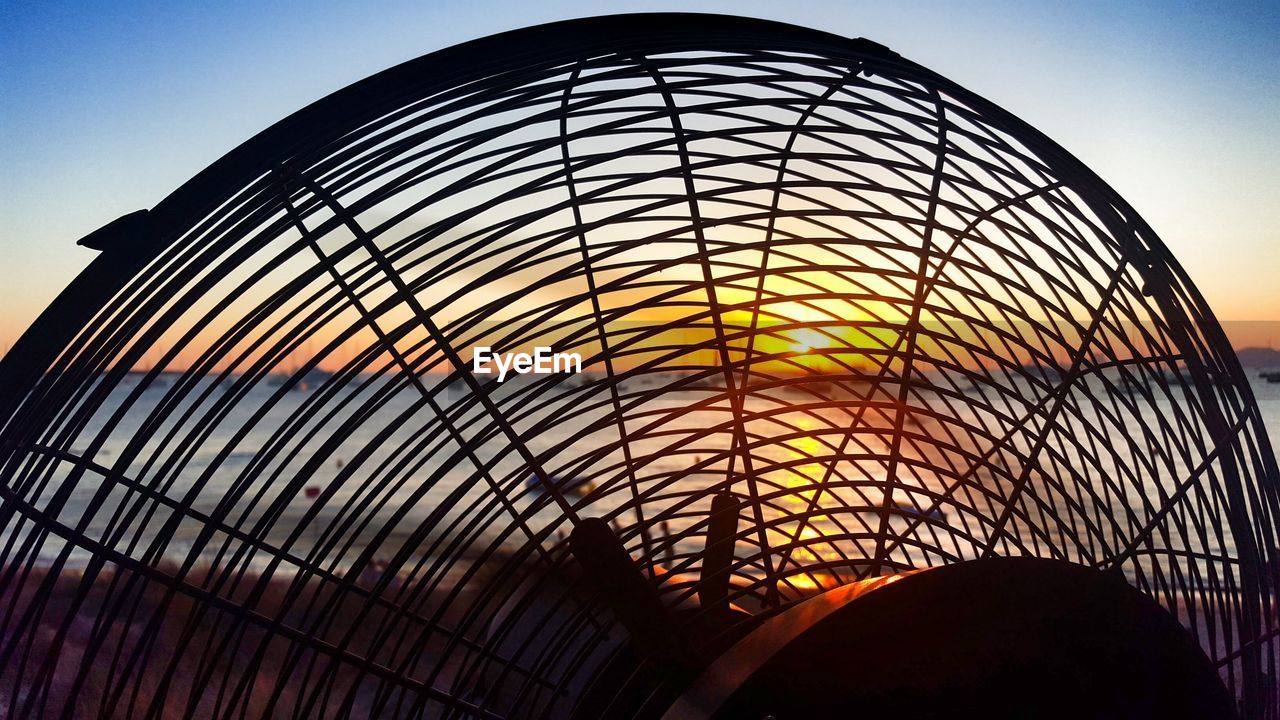 Silhouette electric fan against sky during sunset