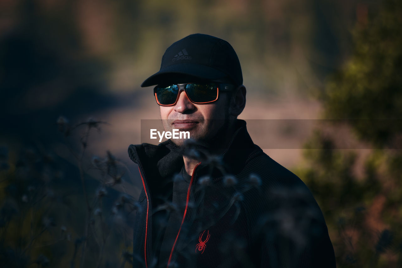 Portrait of young man wearing sunglasses standing outdoors