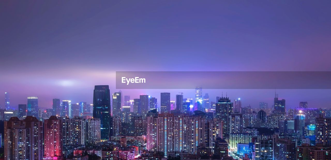 Illuminated city skyline against sky at night