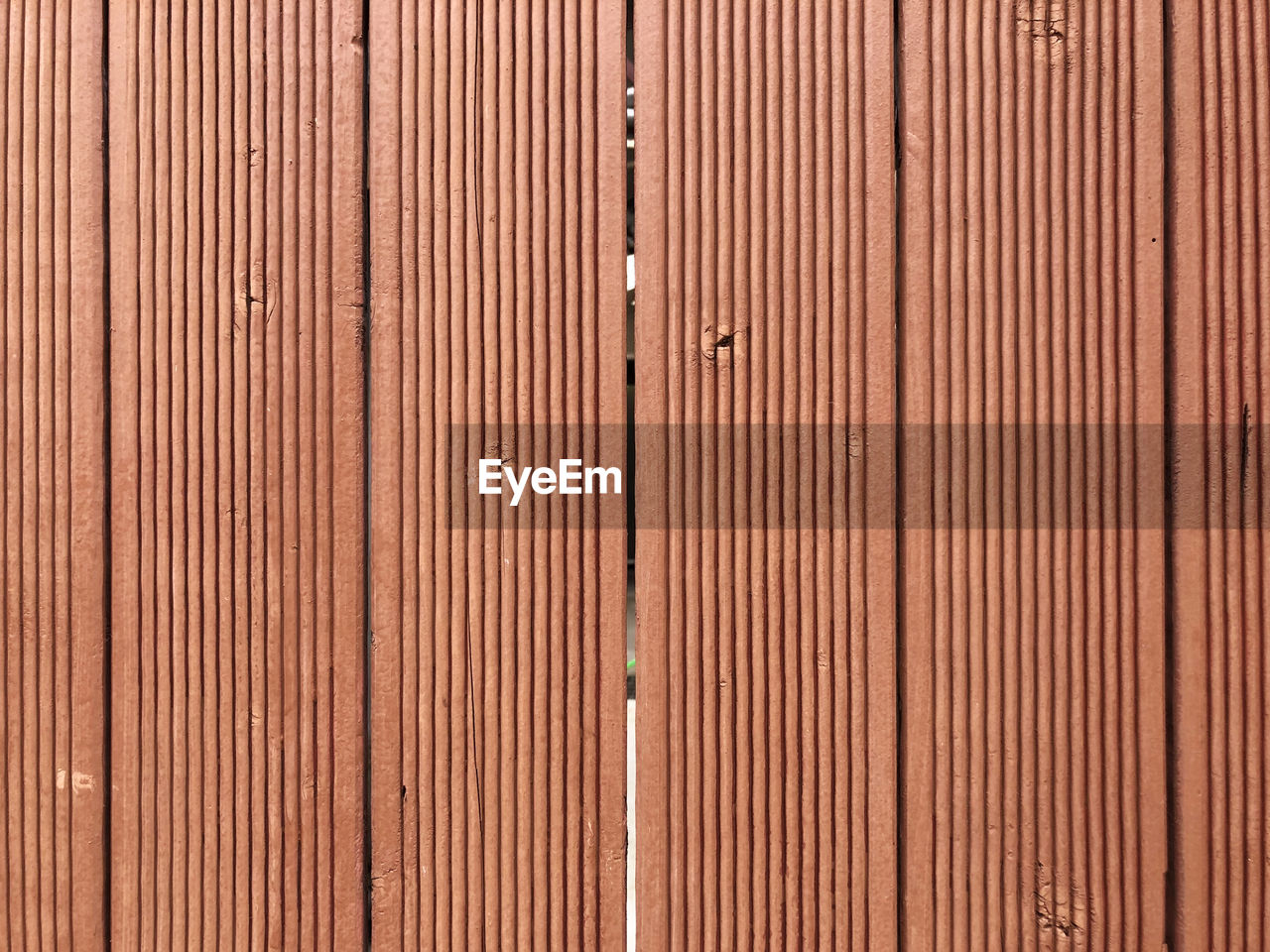 Full frame shot of patterned red-brown wooden wall background for design use