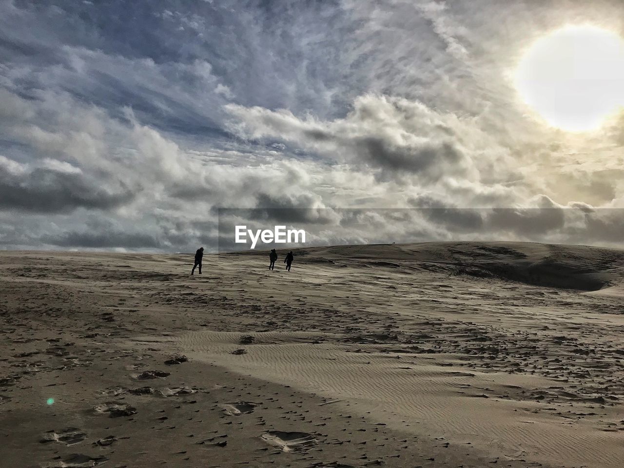 MAN WALKING ON SHORE AGAINST SKY