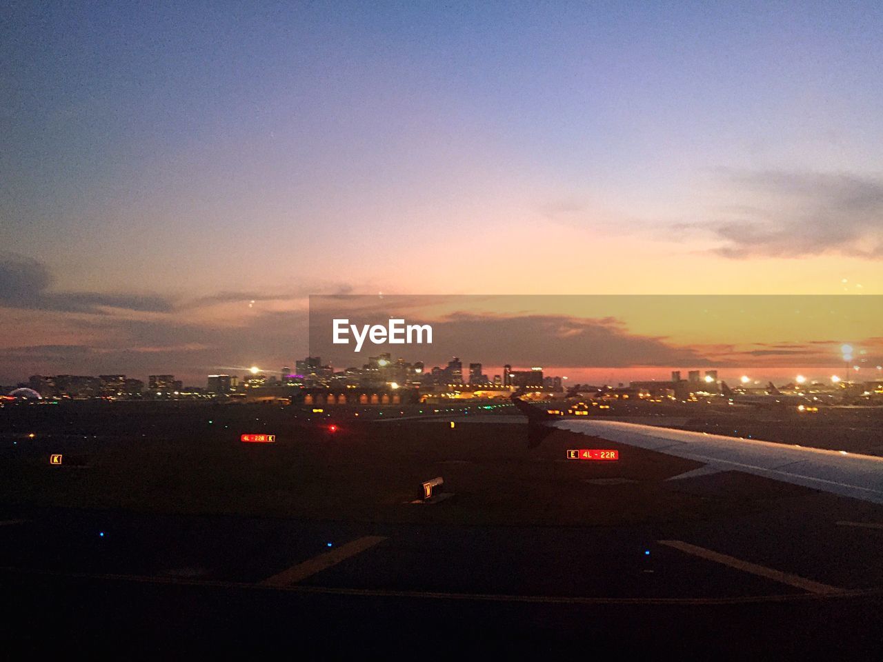 Scenic view of illuminated cityscape against sky during sunset