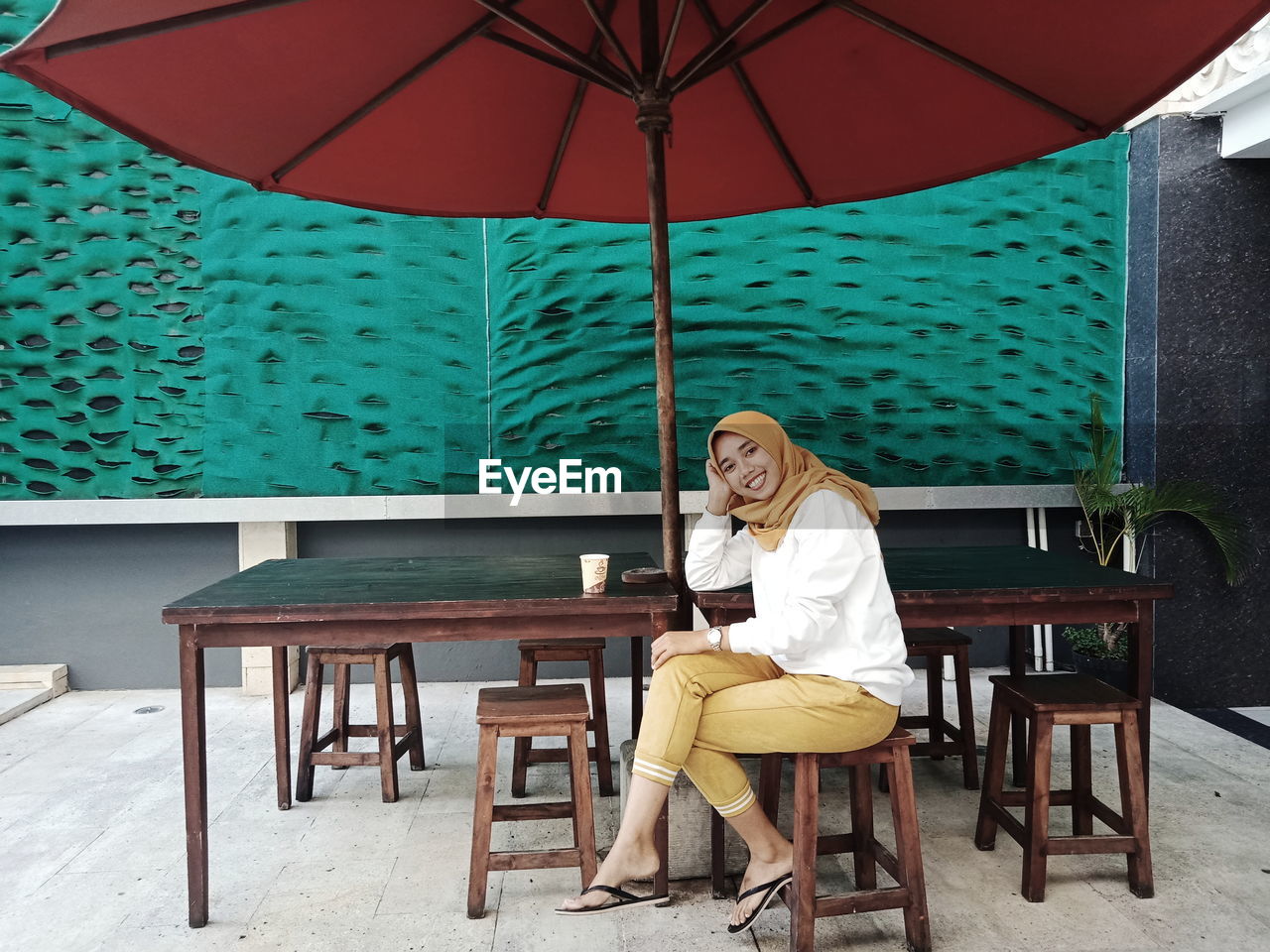 Portrait of smiling woman sitting at sidewalk cafe 