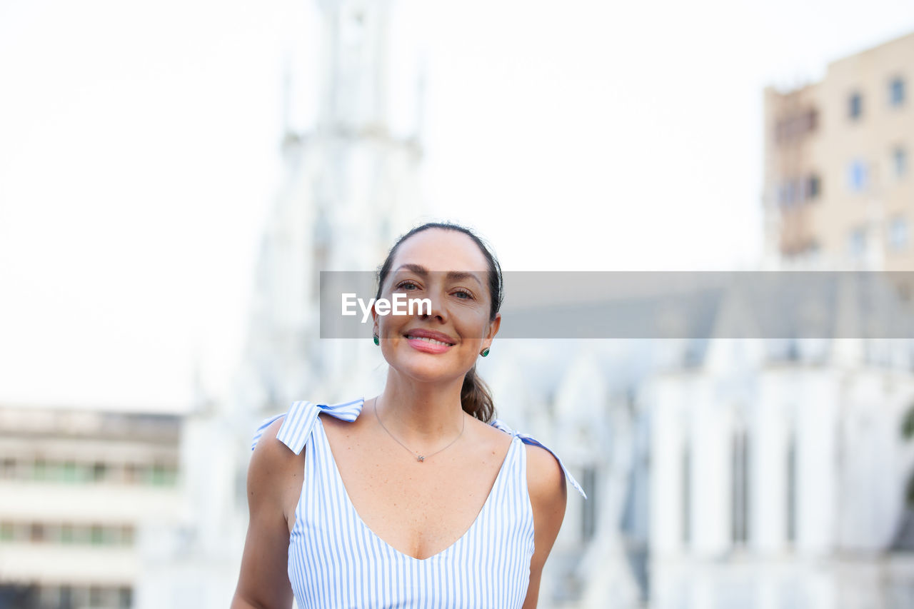 Beautiful tourist woman at the ortiz bridge with la ermita church on background in the city of cali