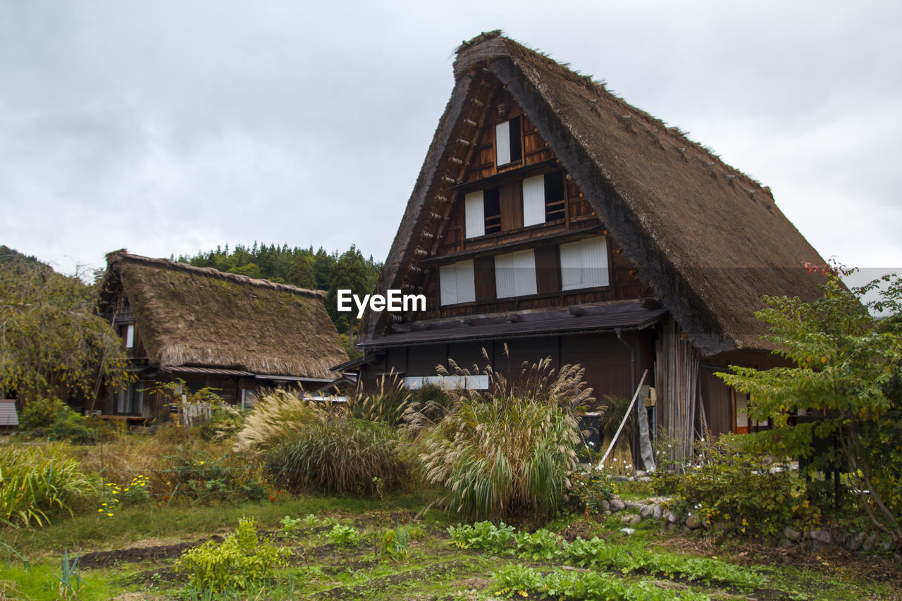 HOUSE ON FIELD AGAINST SKY