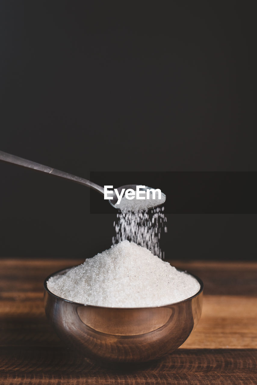 Sugar poured on a wooden table with diabetes word. concept of diabetes and unhealthy eating.