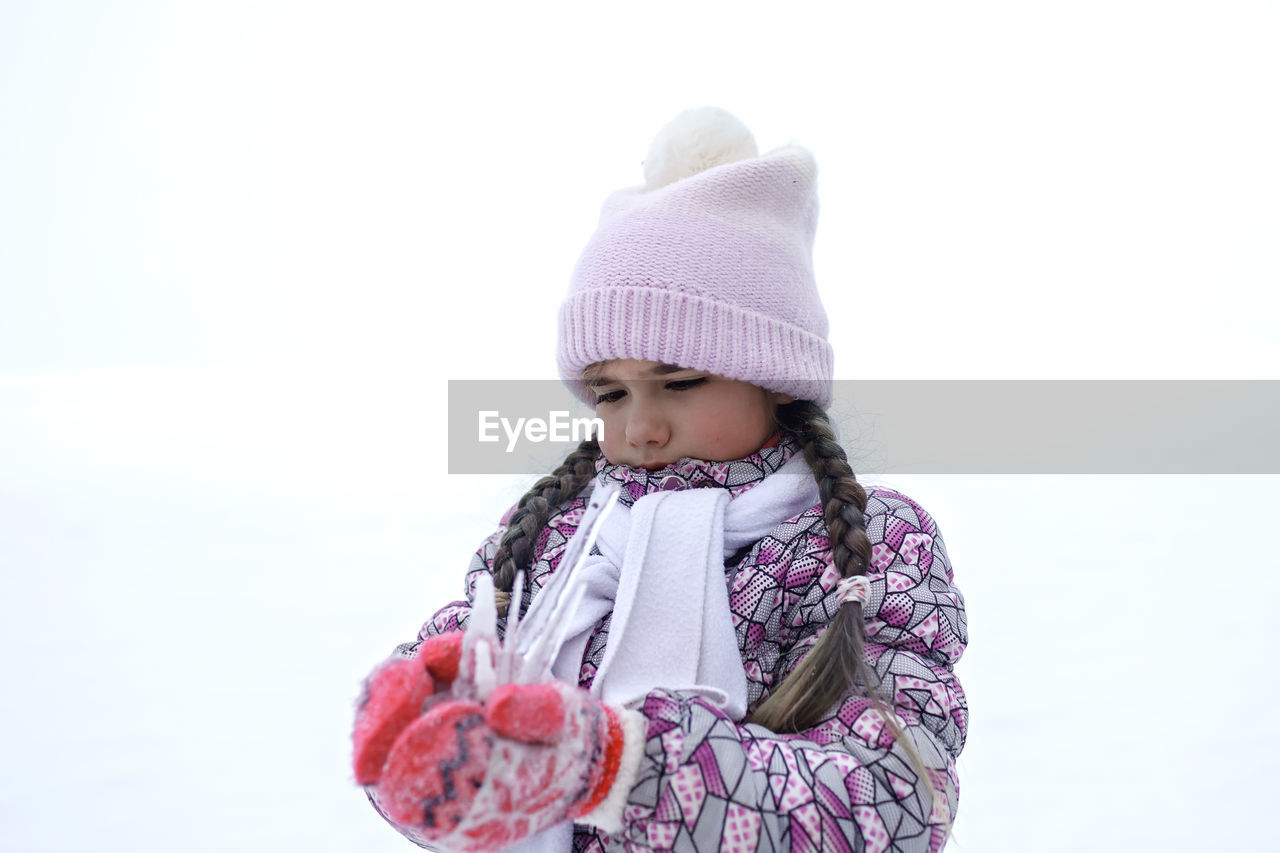 Cute girl holding icicle during winter