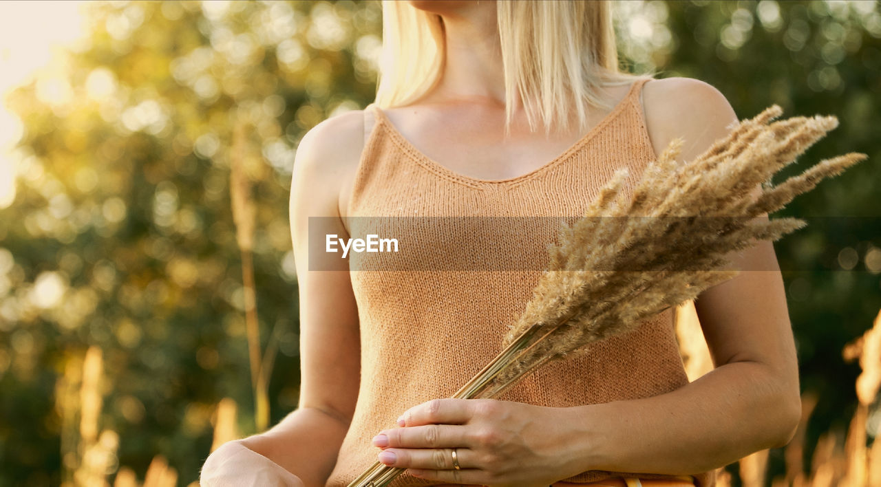 midsection of woman standing against trees