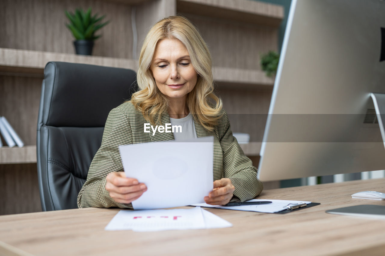 portrait of young woman using digital tablet while sitting on table