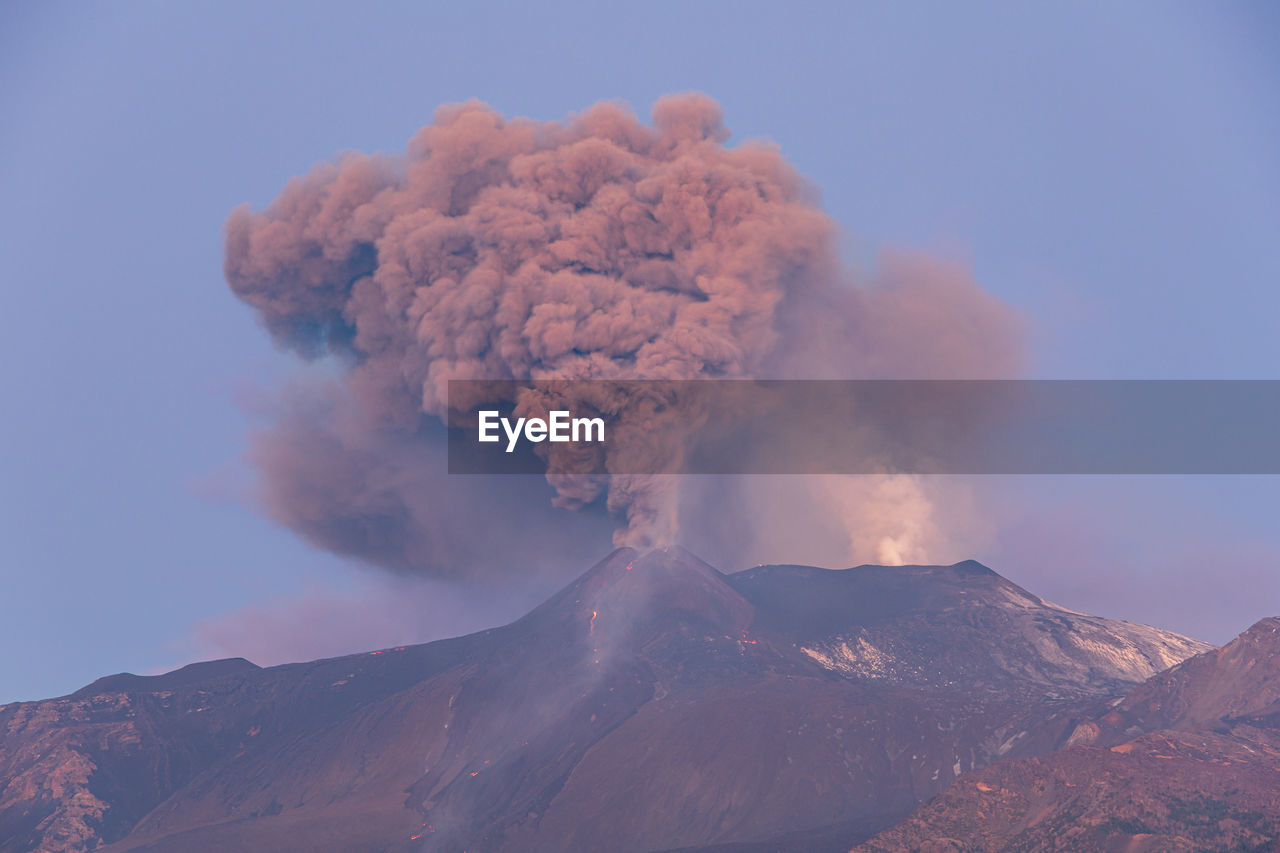 Panoramic view of the strombolian eruption of etna against the sky