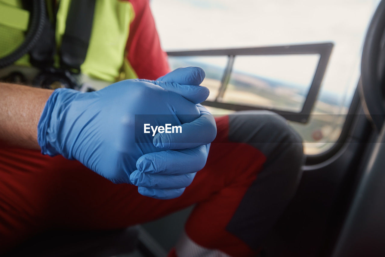 Close-up hands of doctor in surgical gloves inside helicopter of emergency medical service. 