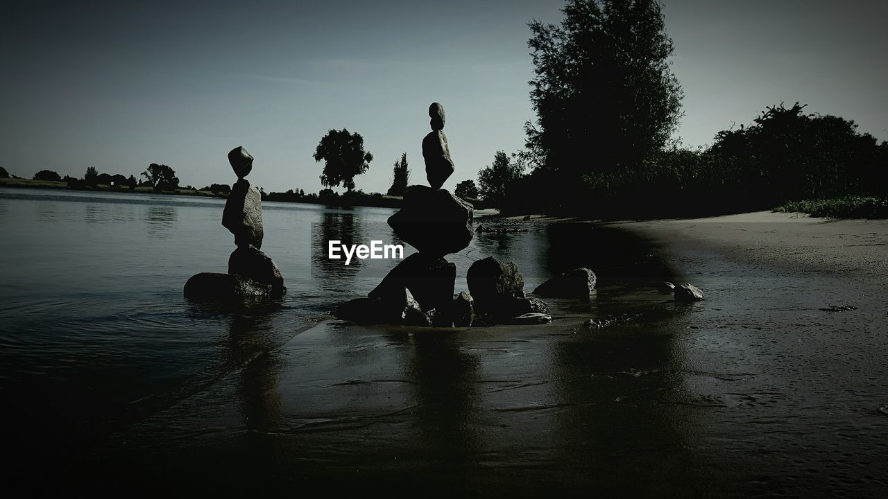 SILHOUETTE OF MEN IN LAKE