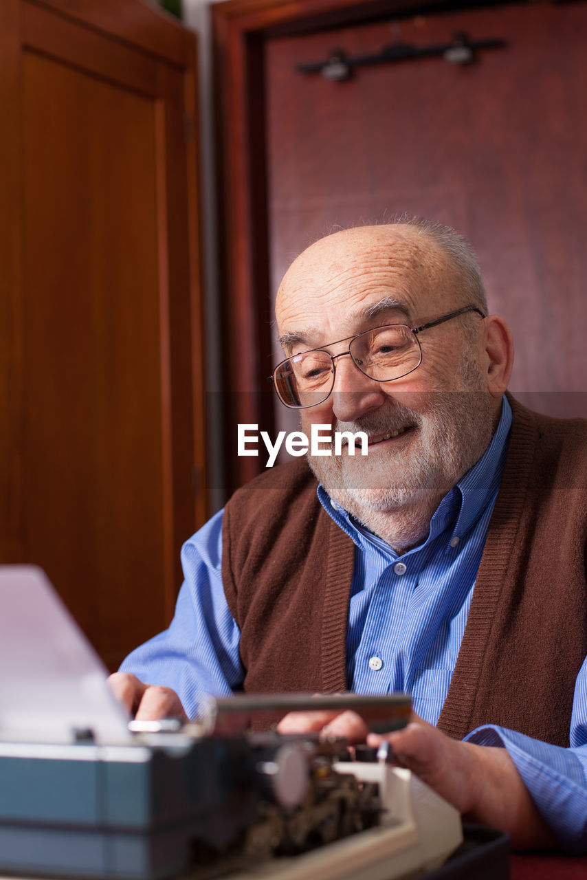 Senior man using typewriter