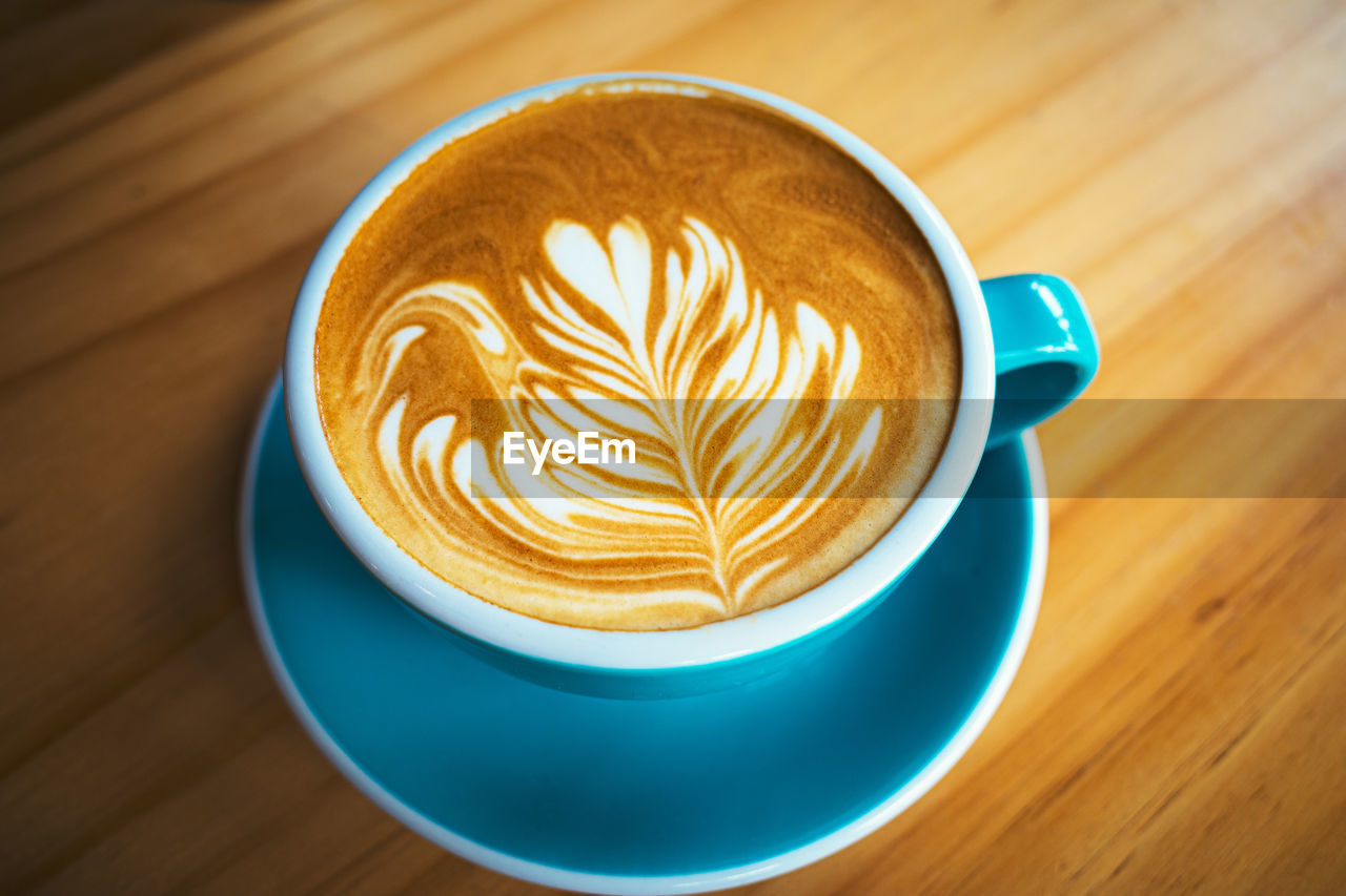 CLOSE-UP OF CAPPUCCINO WITH COFFEE CUP ON TABLE