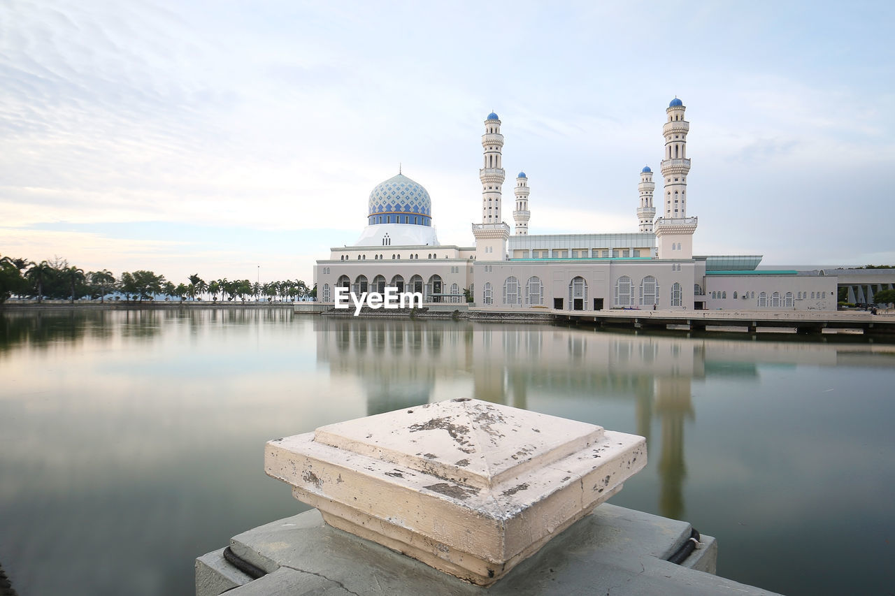 REFLECTION OF TEMPLE IN LAKE AGAINST SKY