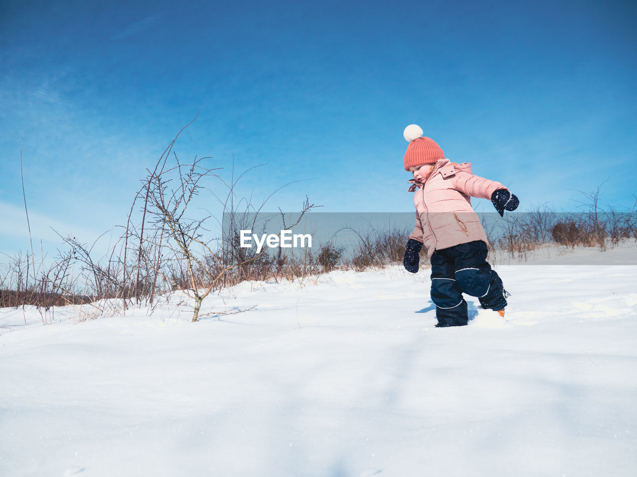 Rear view of boy on snow field against sky