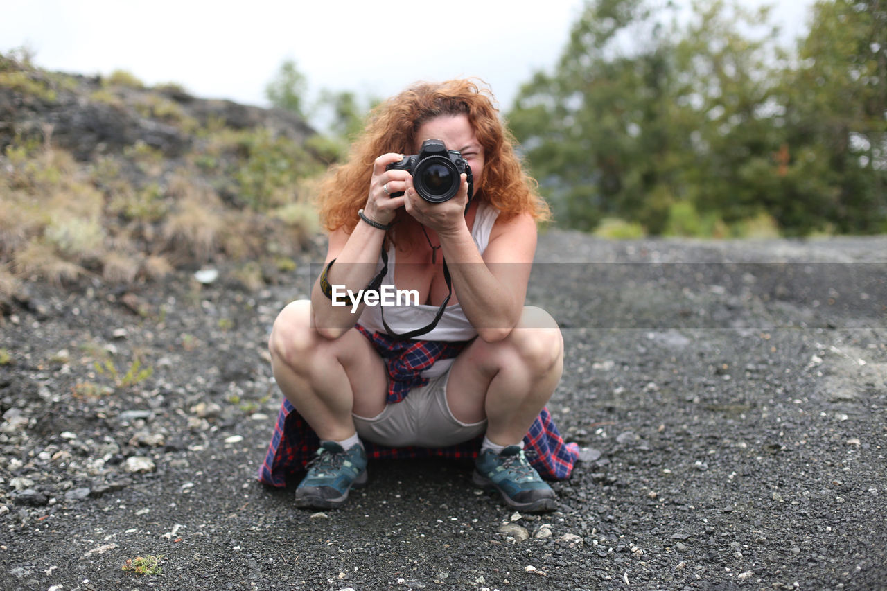 FULL LENGTH PORTRAIT OF YOUNG WOMAN PHOTOGRAPHING