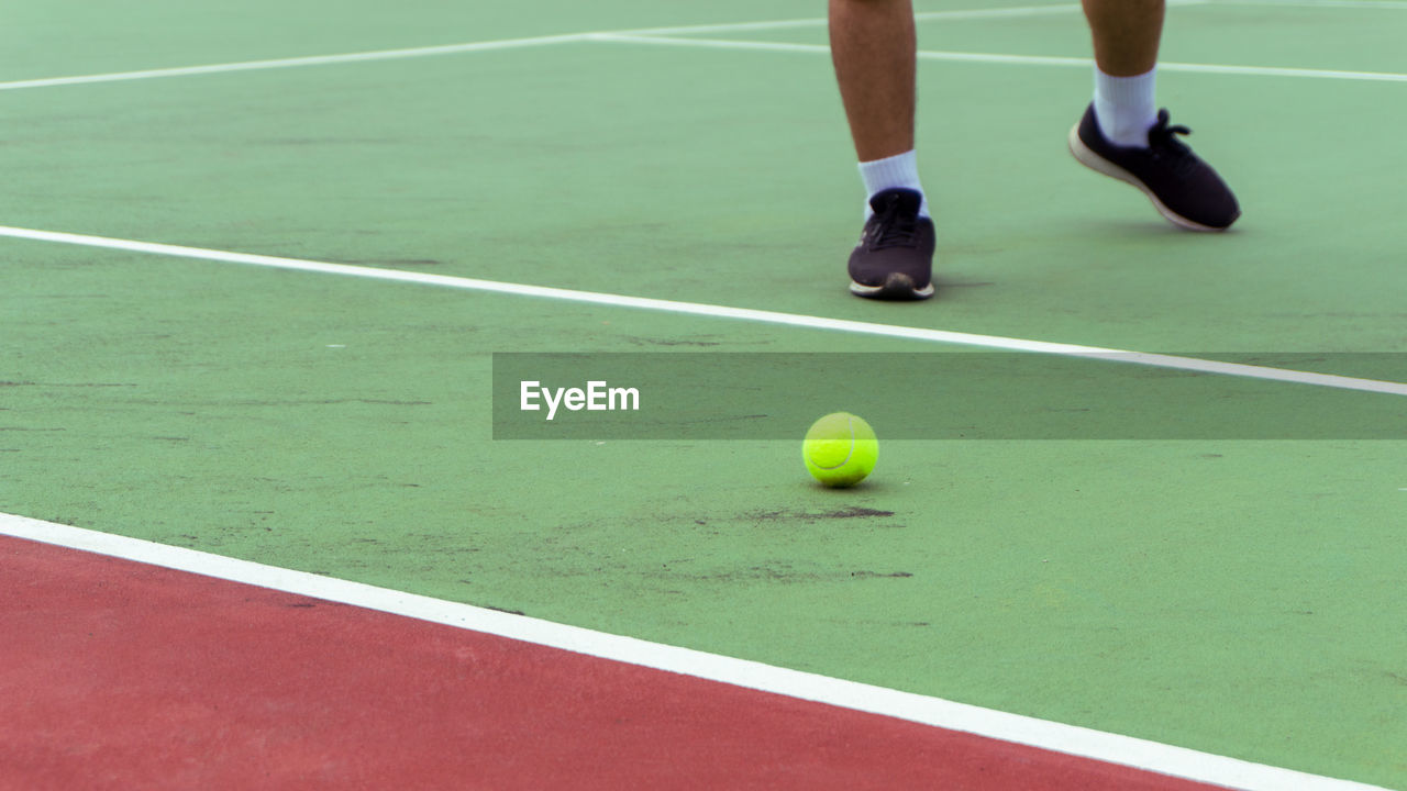 Low section of man playing tennis on court. tennis player shoe