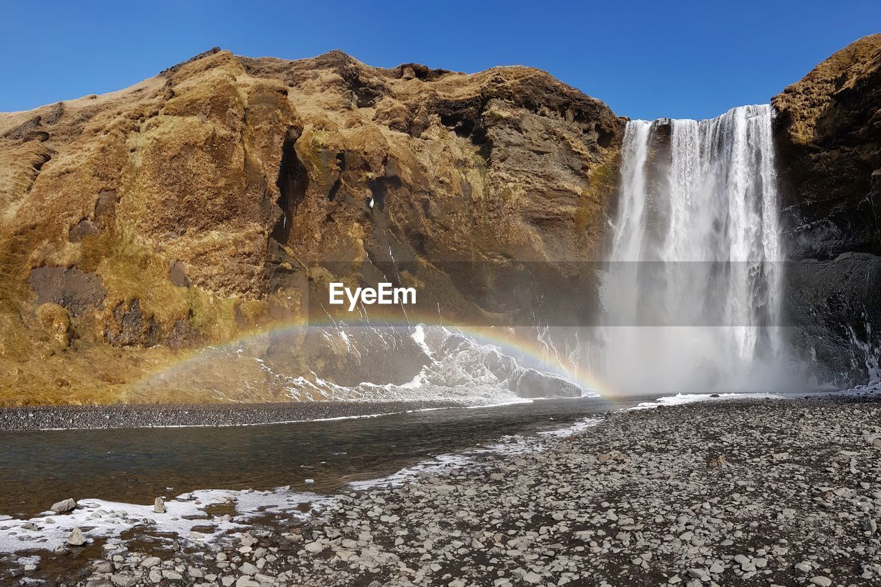 Scenic view of waterfall against sky