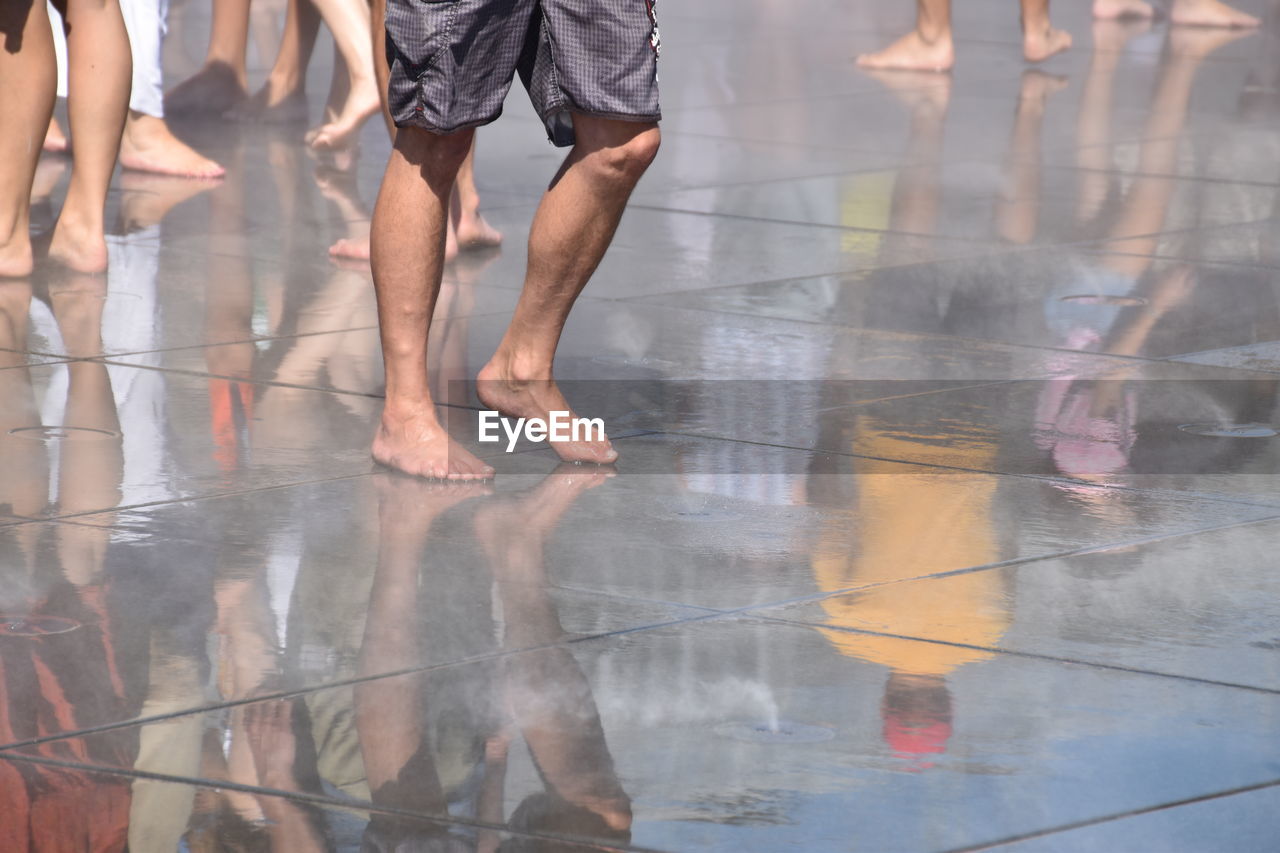 Low section of people on wet floor during rainy season