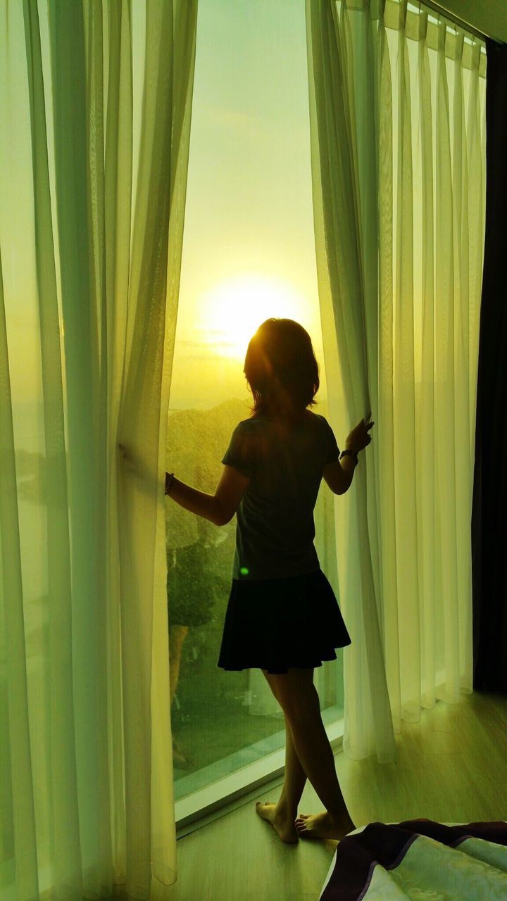 FULL LENGTH OF YOUNG WOMAN STANDING ON RAILING