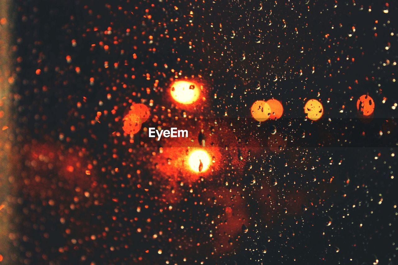 Rain drops on windshield and out of focus city lights