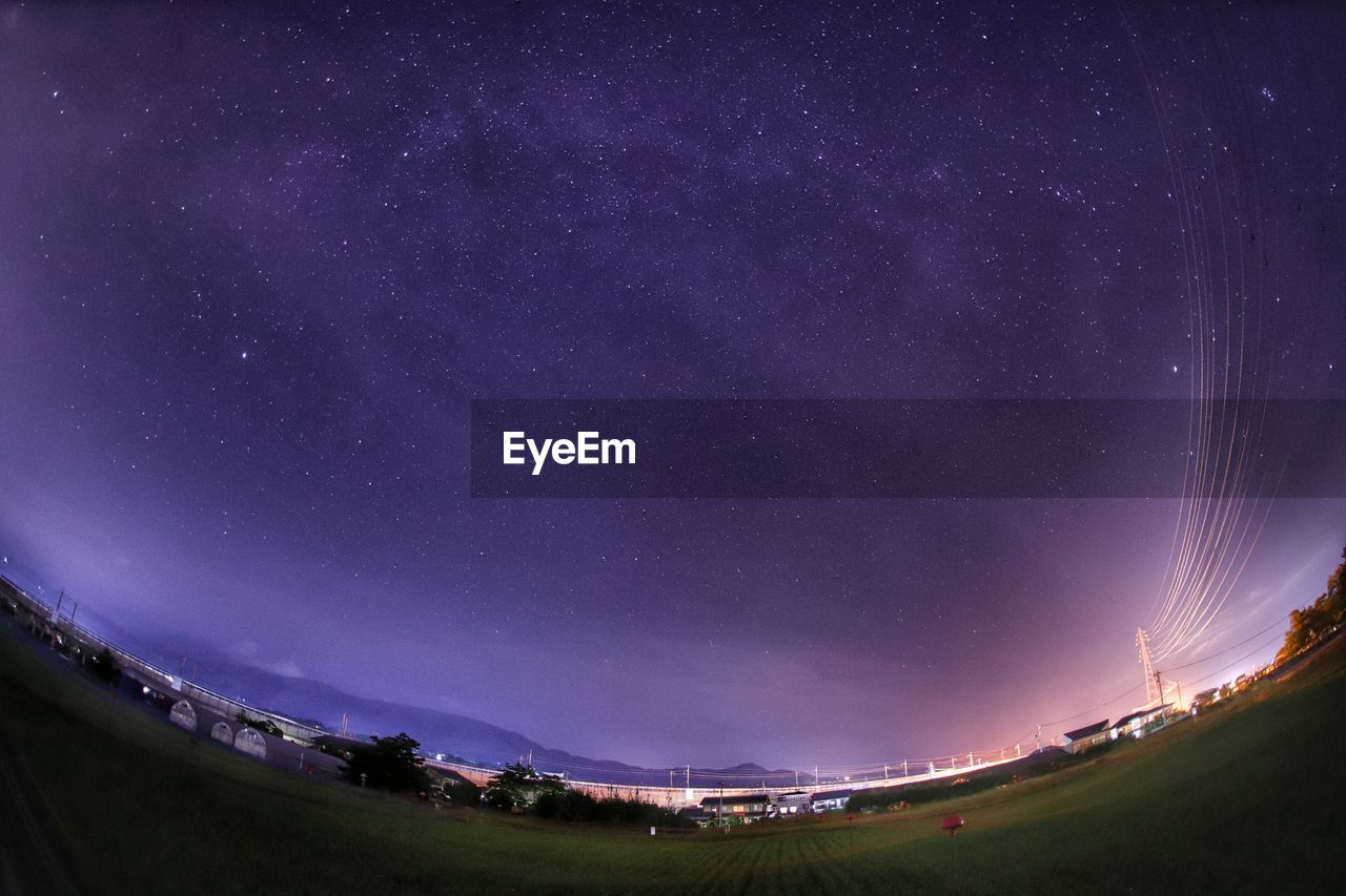 Fish-eye view of field against sky at night